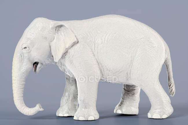 Figura elefante blanco sobre fondo azul - foto de stock