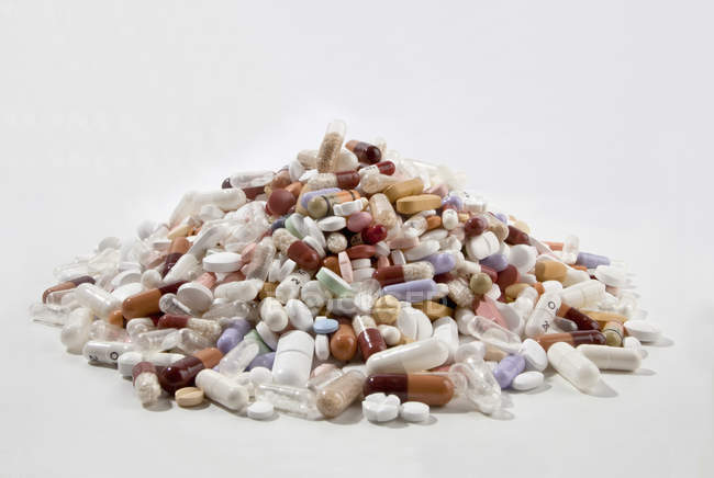 Pile de comprimés et capsules sur fond blanc — Photo de stock