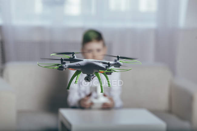 Boy flying drone in living room at home — Stock Photo