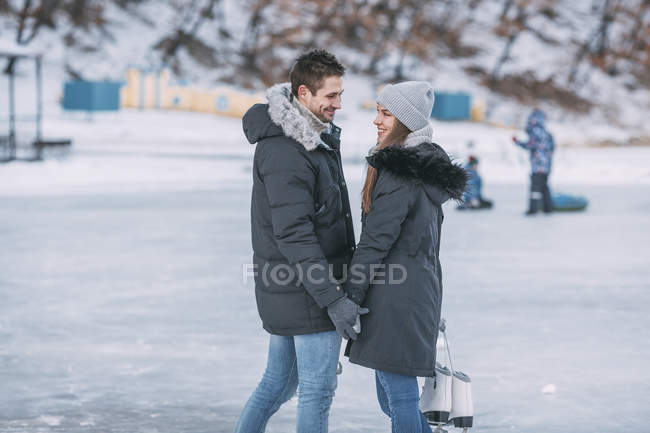 Happy romantic couple standing on ice rink — Stock Photo