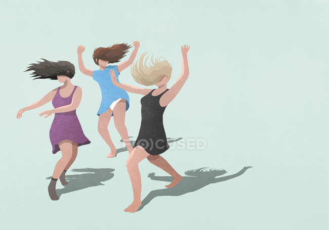 Mujeres despreocupadas en vestidos bailando sobre fondo azul - foto de stock
