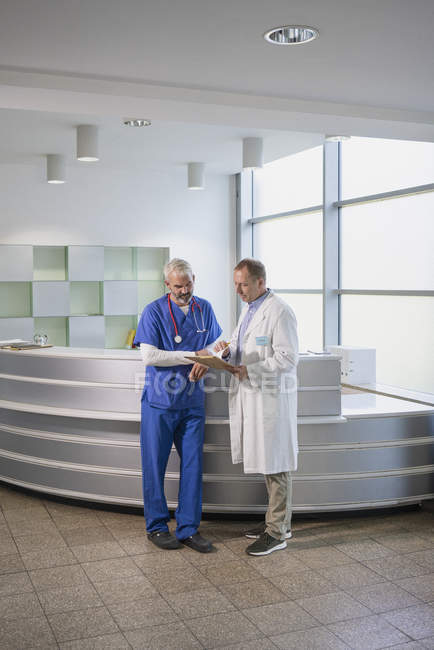 Male doctors discussing medical record in hospital — Stock Photo