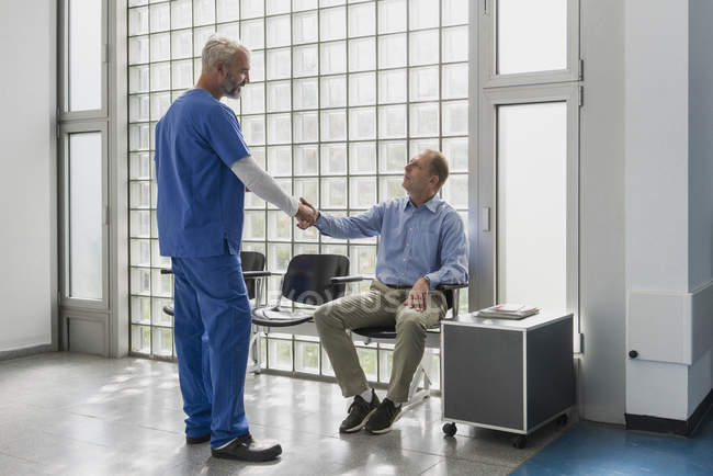 Arztgruß, Händeschütteln mit Patient im Wartezimmer der Klinik — Stockfoto