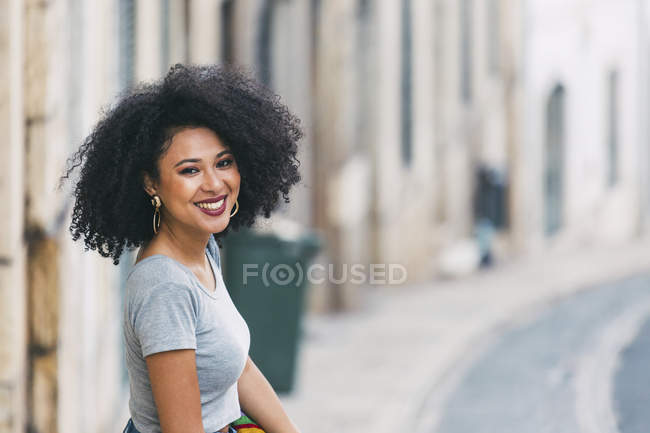 Портрет молодої жінки, посміхаючись на вулиці — стокове фото