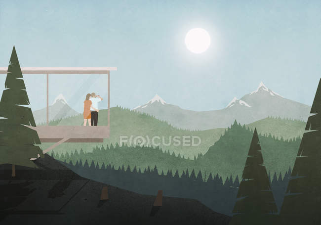 Пара смотрит на идиллический, солнечный вид на горы и лес из стеклянного дома — стоковое фото