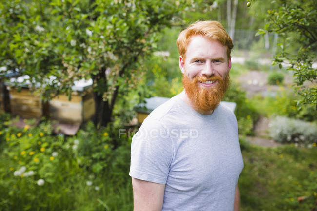 Portrait smiling, confident man with red hair in garden — Stock Photo