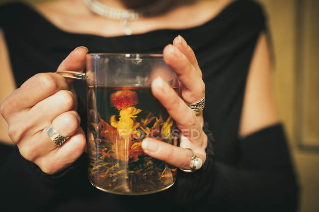 Close up woman drinking blooming tea — Stock Photo