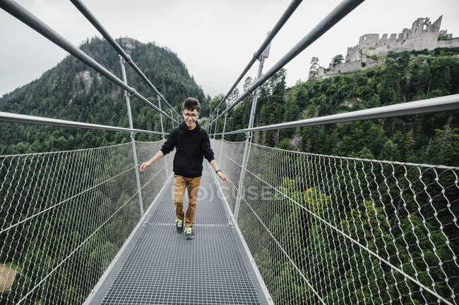 Ragazzo adolescente che cammina attraverso Highline 179 ponte sospeso, Tirolo, Austria — Foto stock