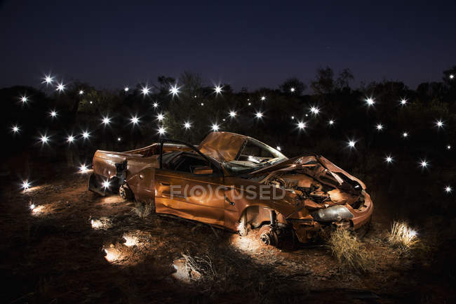 Lights illuminating art installation of crushed car — Stock Photo