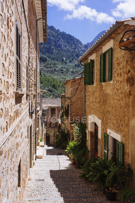 Sunny cobblestone street and houses, Fornalutx, Mallorca, Islas Baleares, España - foto de stock