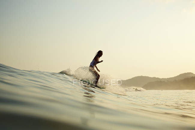 Surfeuse chevauchant la vague océanique — Photo de stock