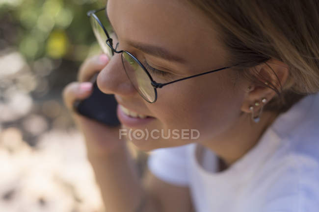 Молода жінка розмовляє на смартфоні — стокове фото