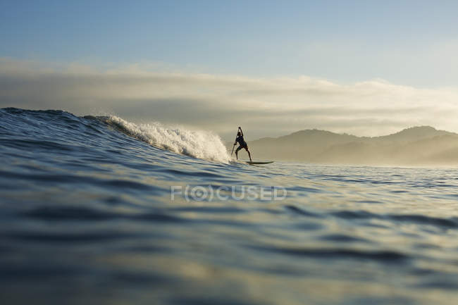 Silhueta de paddle boarder montando onda oceânica, Sayulita, Nayarit, México — Fotografia de Stock