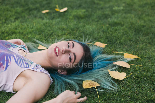 Portrait Of Woman With Blue Hair Laying In Grass With Autumn Leaves Long Hair Horizontal Stock Photo 326458734