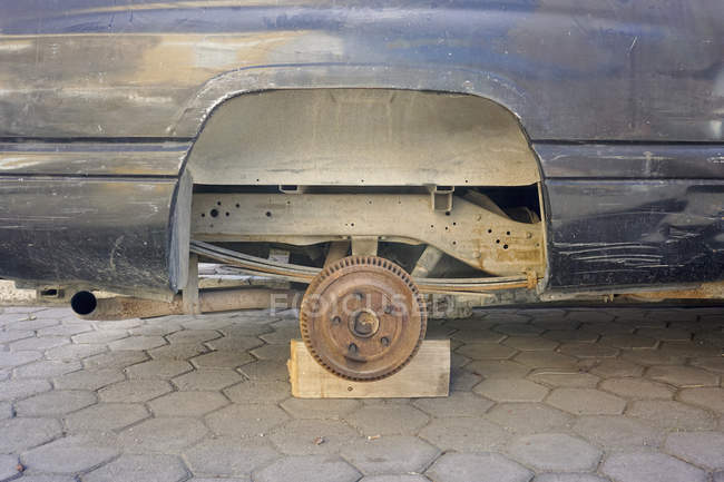 Rueda perdida coche oxidado - foto de stock