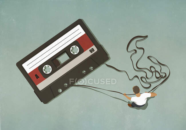 Man pulling tape from large cassette — Stock Photo