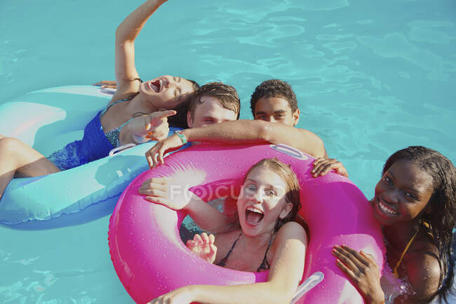Retrato juguetón adolescentes amigos disfrutando de fiesta en la piscina - foto de stock