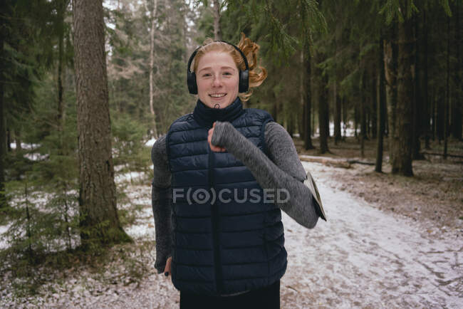 Уверенная в себе женщина, бегущая в снежных лесах — стоковое фото
