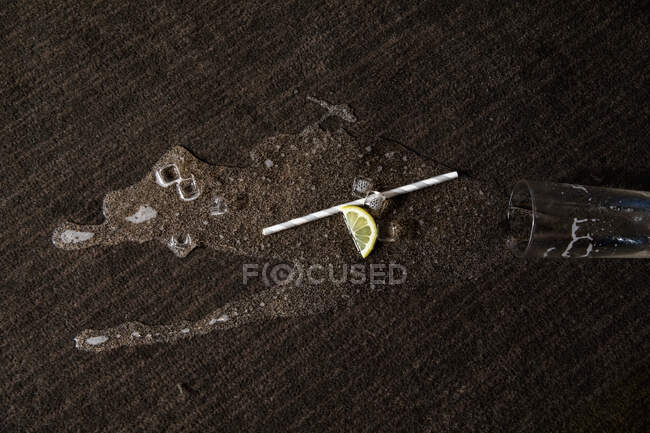 Cóctel derramado, paja y limón en la alfombra - foto de stock