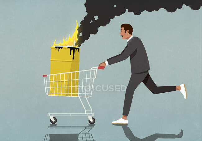 Бізнесмен штовхає кошик з палаючим барилом для олії. — стокове фото