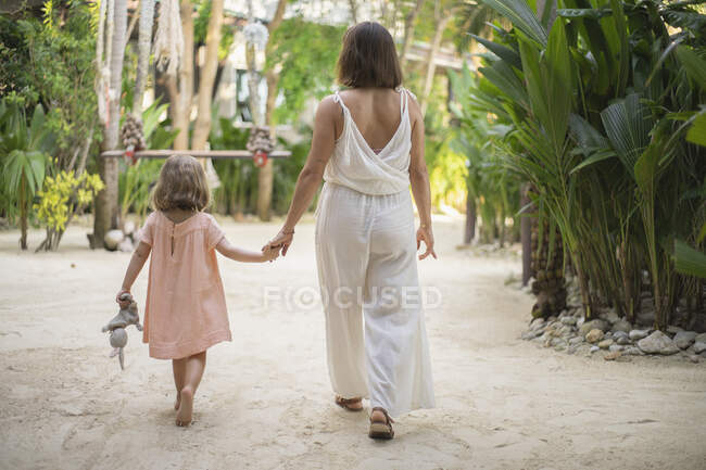 Madre E Figlia Che Si Tengono Per Mano Passeggiando Al Resort Tropicale