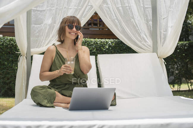 Щаслива жінка розмовляє на смартфоні в кабані. — стокове фото