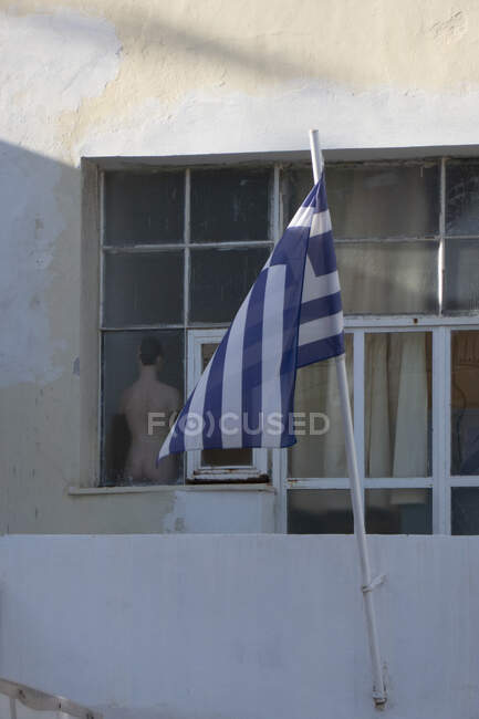 Drapeau grec sur mât de drapeau fenêtre extérieure avec mannequin, Grèce — Photo de stock