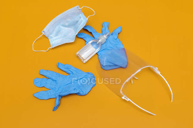 Mascarilla protectora, guantes, desinfectante de manos y gafas - foto de stock