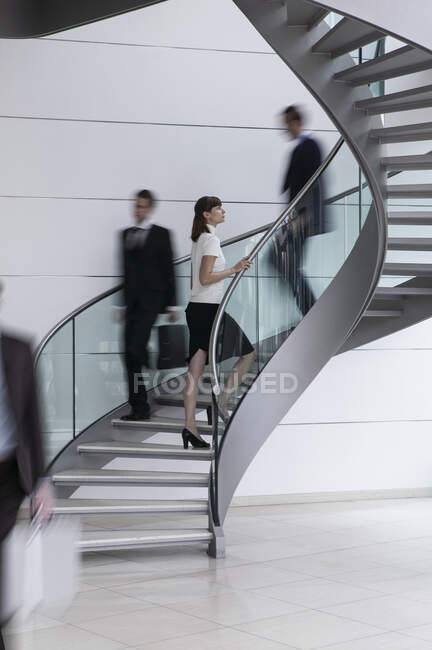 Joven empresaria ascendiendo escalera de caracol en el cargo - foto de stock