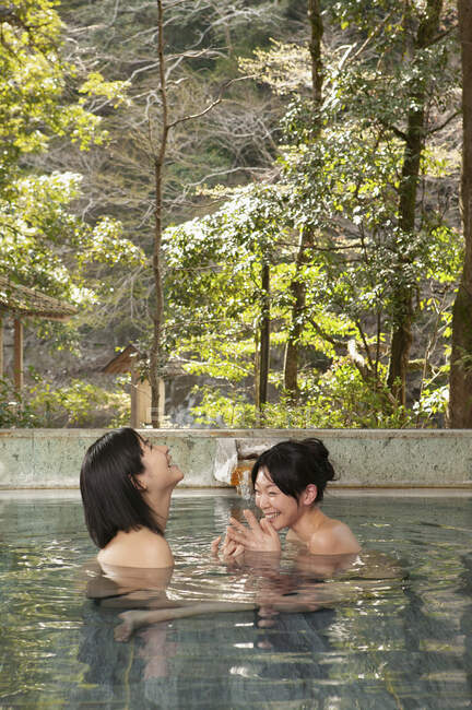 Felice giovane donne amiche ammollo in piscina a Onsen — Foto stock