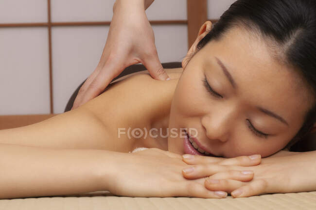 Primer plano hermosa mujer joven serena recibiendo masaje en el spa - foto de stock