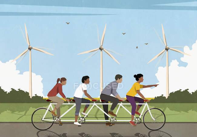 Amigos montando en bicicleta en tándem a lo largo de campo idílico con turbinas eólicas - foto de stock