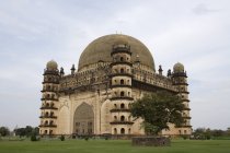 Side view of Gol Gumbaz temple over green grass lawn during daytime, Karnataka, India — стоковое фото