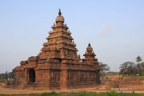 View of Shore Temple over green grass against clear blue sky, Mahabalipuram, India — Stock Photo