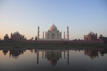 Vista frontal de Taj Mahal contra a água da lagoa com reflexão durante o dia — Fotografia de Stock