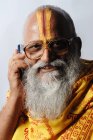 Индуистский священник говорит по мобильному телефону. Мумбаи, Махараштра, Индия — стоковое фото
