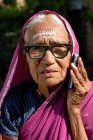 Portrait of indian rural old woman in glasses speaking on mobile phone. Lonavala, Maharashtra, India — Stock Photo