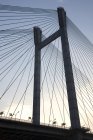 Vista a basso angolo di costruzione del ponte con fili contro il cielo — Foto stock