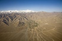 A vista aérea da neve cobriu as montanhas do Himalaia com casas e campos ao longo do rio no vale perto de Leh, como visto no voo de Deli para Leh-Ladakh. Índia — Fotografia de Stock