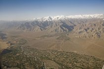 Aerial view of the snow covered Himalaya mountains with the Indus river and the villages with their fields in the valley near Leh as seen on the flight from Delhi to Leh-Ladakh.India — Stock Photo