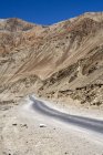 Narrow tar bituman road on the Leh-Kargil road stretch in the barren cold dsert landscape of Ladakh.India — Stock Photo