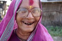 Smiling rural woman with black teeth in pink sari. Salunkwadi, Ambajogai, Beed, Maharashtra, India — Stock Photo