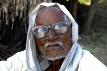 Retrato de granjero indio en ropa nacional con bigote blanco y gafas. Salunkwadi, Ambajogai, Beed, Maharashtra, India - foto de stock