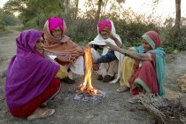 Aldeanos indios con ropa nacional sentados al lado de la hoguera. Salunkwadi, Ambajogai, Beed, Maharashtra, India - foto de stock