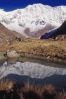 Blick auf Berggipfel und kleinen Teich mit Spiegelung am Tag — Stockfoto