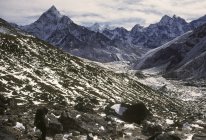 Blick auf Berggipfel und Felder mit Steinen am Tag — Stockfoto