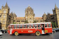 Autobús que pasa por la carretera cerca de Victoria Terminus llamado Chhatrapati Shivaji Terminus Station. Bombay Mumbai, Maharashtra, India - foto de stock