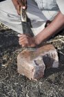 Imagen recortada de cortador de caña de azúcar afilando su herramienta por piedra. Salunkwadi, Taluka, distrito de Ambejpgai, Beed, Maharashtra, India - foto de stock