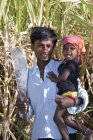 Fermier indien avec couteau et bébé au champ. Salunkwadi, Taluka, district d'Ambejpgai, Beed, Maharashtra, Inde — Photo de stock