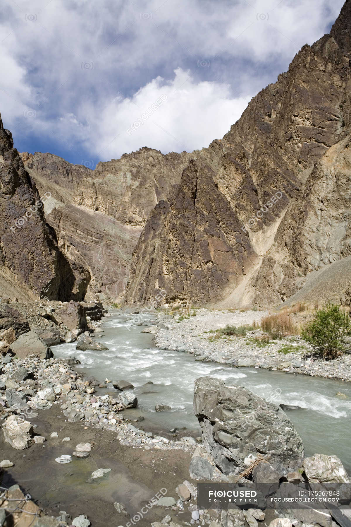 A stream cutting across the rocky mountains near cliffs of Ladakh ...